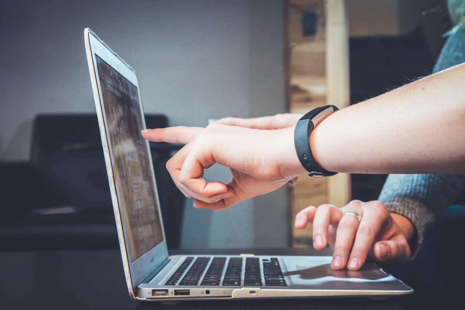 Hands pointing at a computer screen